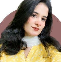 A woman with black hair wearing a yellow patterned outfit and a white scarf, posing for a selfie with a circular maroon background. This image relates to Scales Health & Wellness DTC Brands.